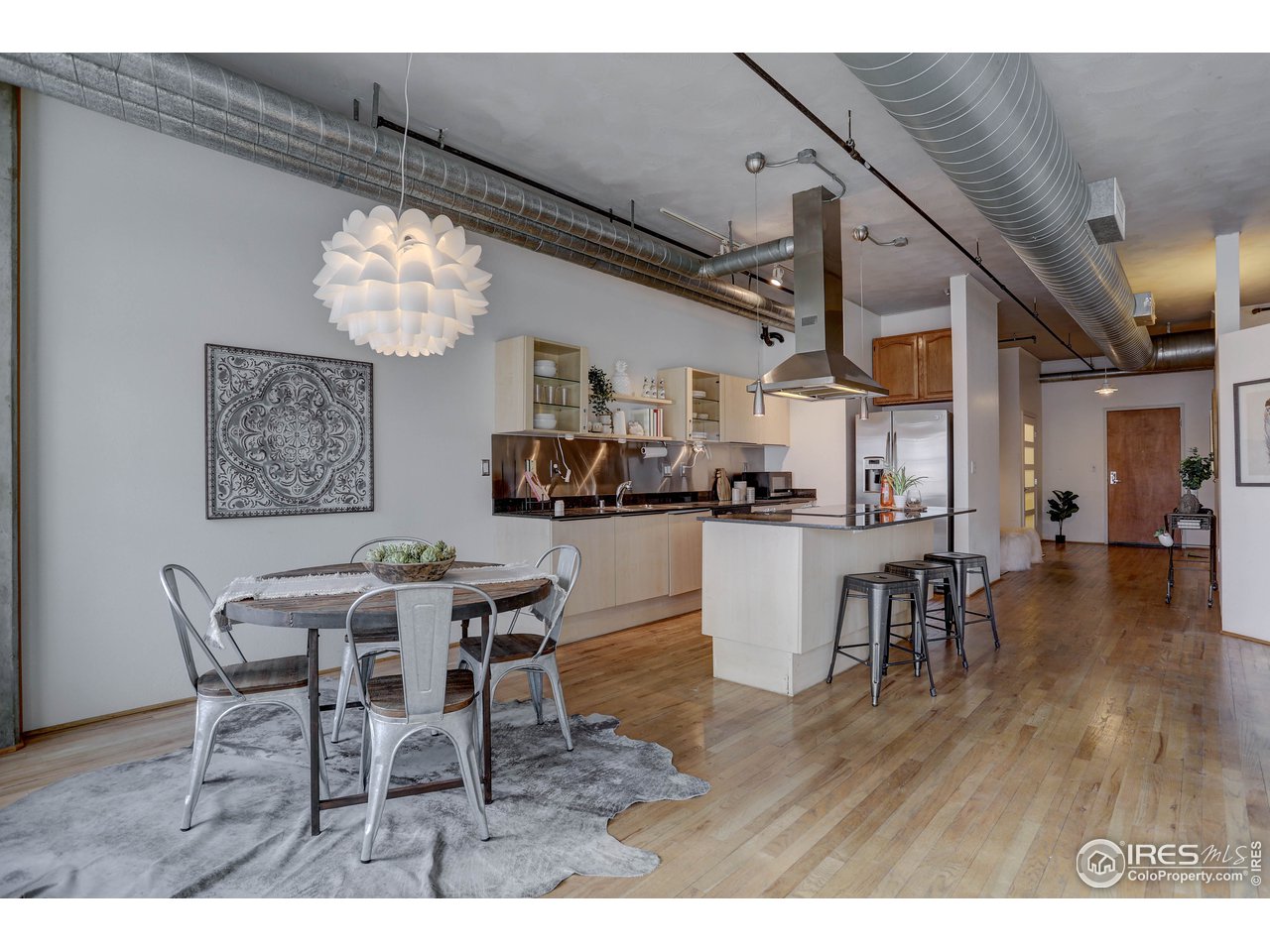 1499 Blake Street, Unit 6G Denver, CO 80202 - Photo 10 of 37 a dining room with wooden floor and chandelier