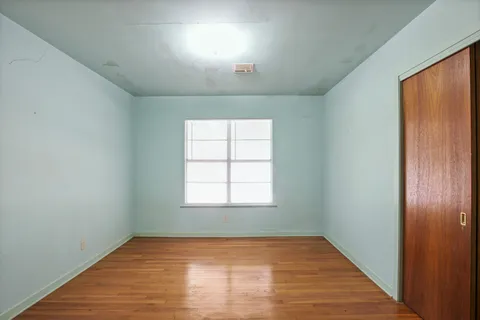 a view of an empty room with wooden floor