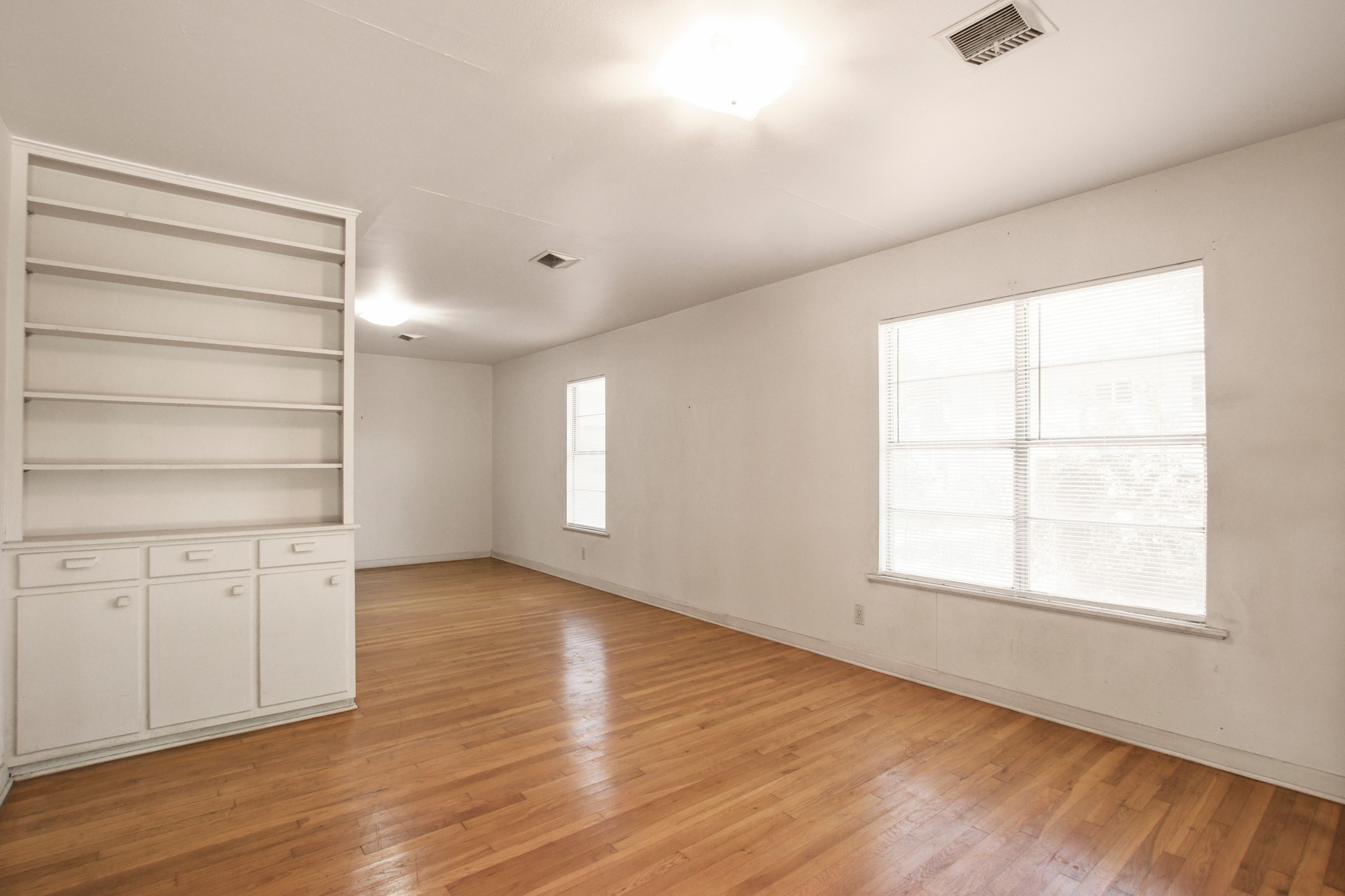 1007 Kimbro Street Taylor, TX 76574 - Photo 4 of 32 an empty room with wooden floor closet and windows