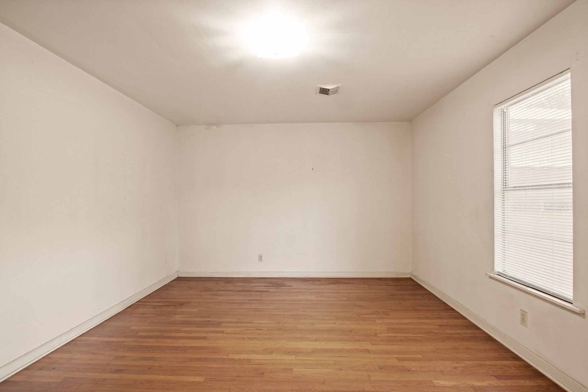 1007 Kimbro Street Taylor, TX 76574 - Photo 6 of 32 wooden floor in an empty room with a window