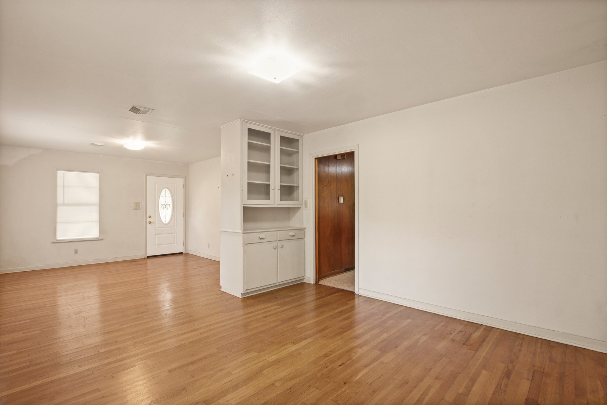 1007 Kimbro Street Taylor, TX 76574 - Photo 7 of 32 an empty room with wooden floor and windows