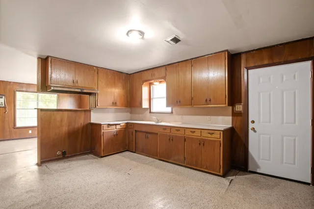 a kitchen with stainless steel appliances granite countertop wooden cabinets a sink and a refrigerator