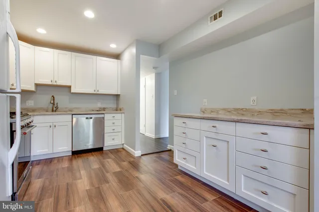 a kitchen with granite countertop white cabinets and white appliances