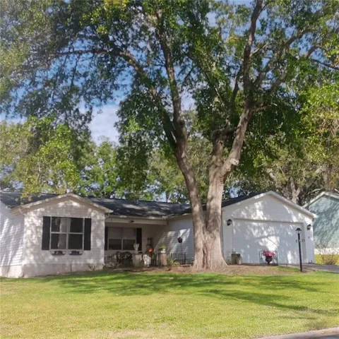 a front view of house with yard and trees in the background