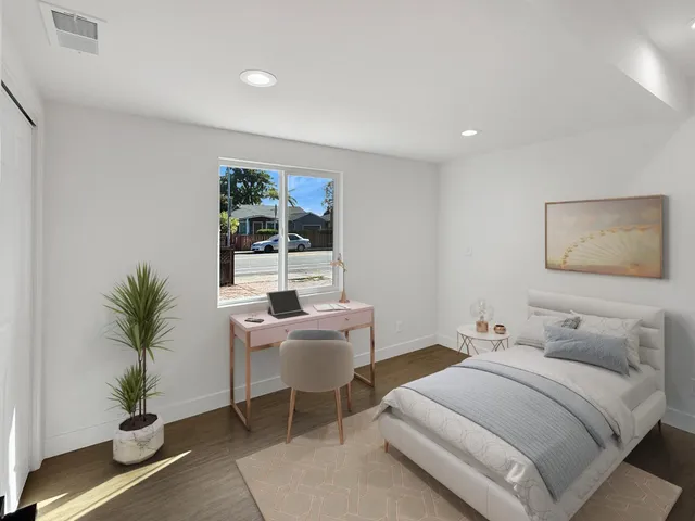 a bedroom with a large bed and a potted plant