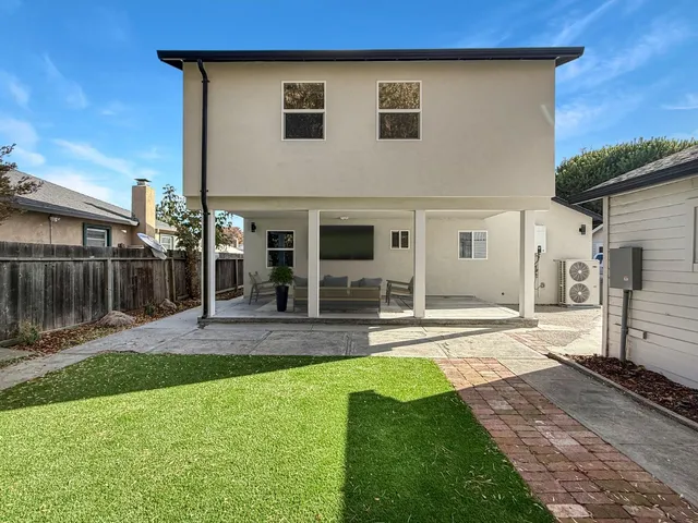 a view of a house with a yard and a patio