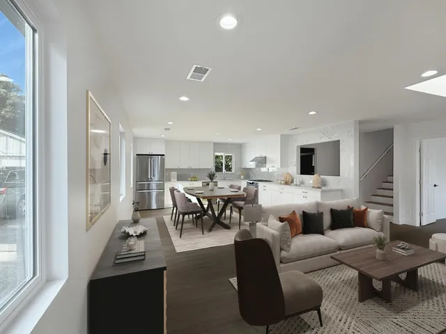 a living room with furniture kitchen view and a large window