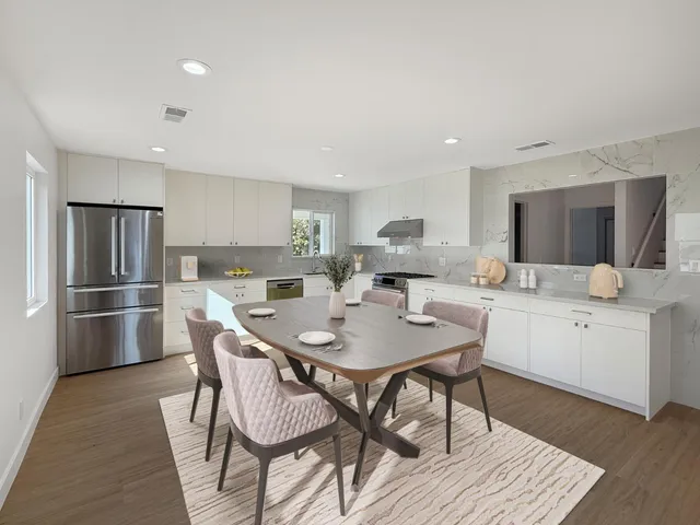 a kitchen with a dining table chairs refrigerator and cabinets