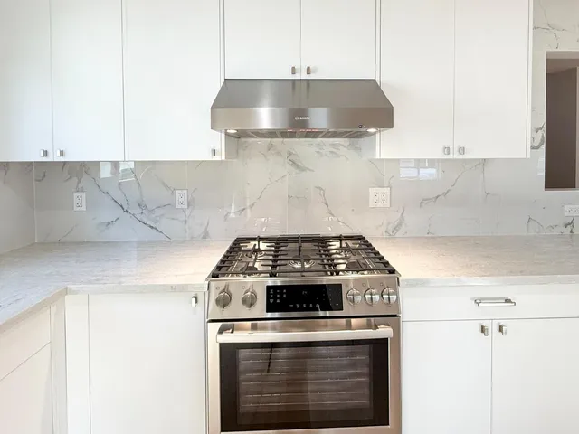 a stove top oven sitting inside of a kitchen