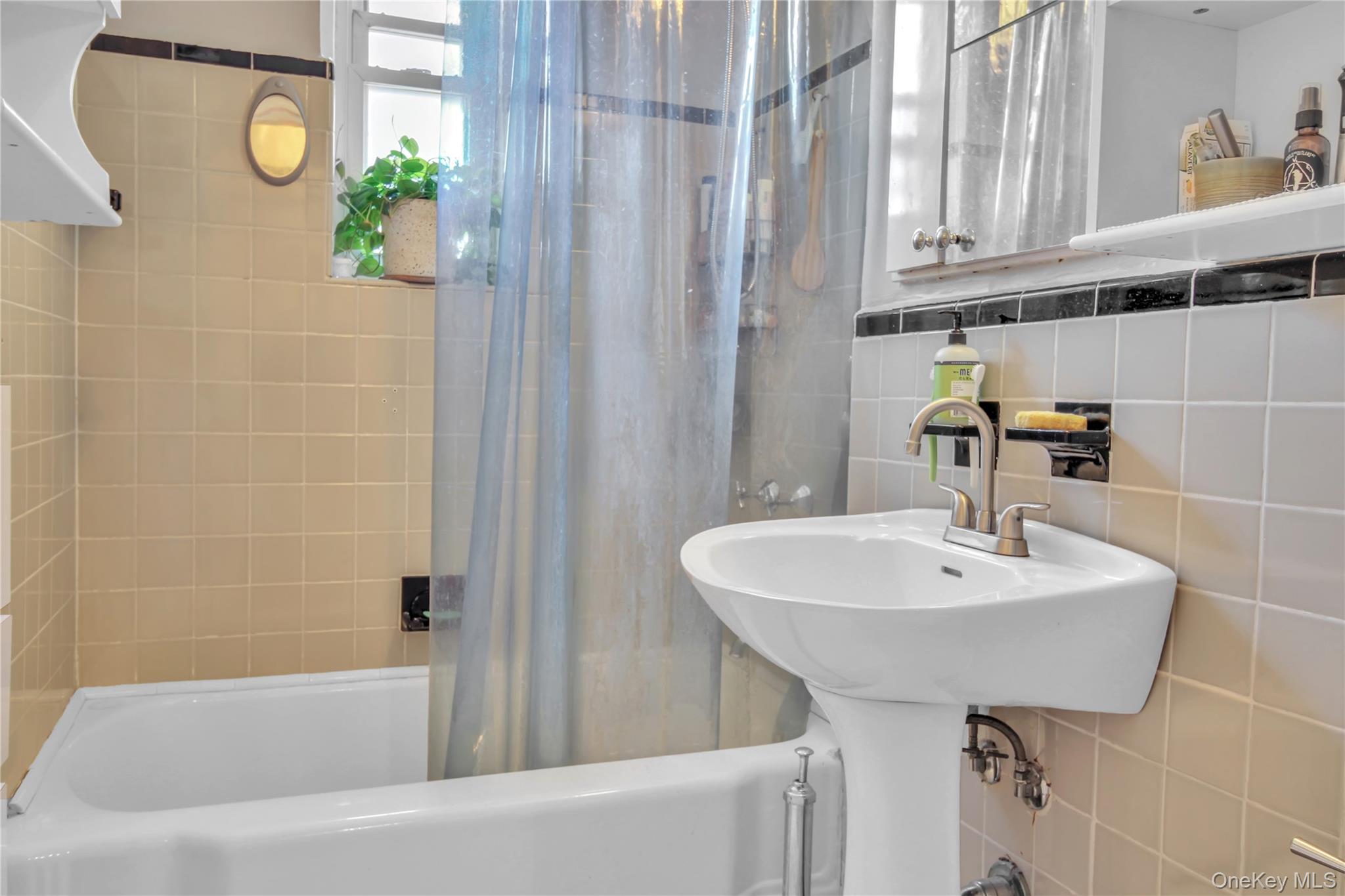 35-40 75th Street, Unit 5B Queens, NY 11372 - Photo 9 of 20 a bathroom with a sink and a bathtub