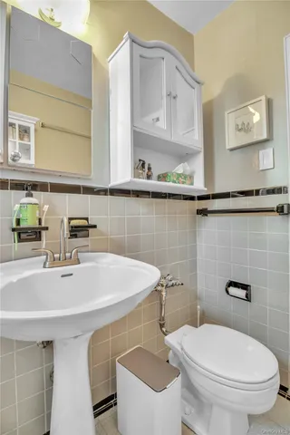 a bathroom with a sink a toilet and mirror