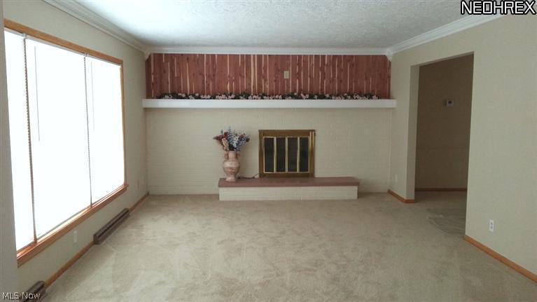 1998 Wyndham Road Akron, OH 44313 - Photo 4 of 25 The living room provides plenty of sunlight with the oversized front windows. New carpet and paint. Electric fireplace, could be converted. Doorway to left leads to dining room and kitchen.