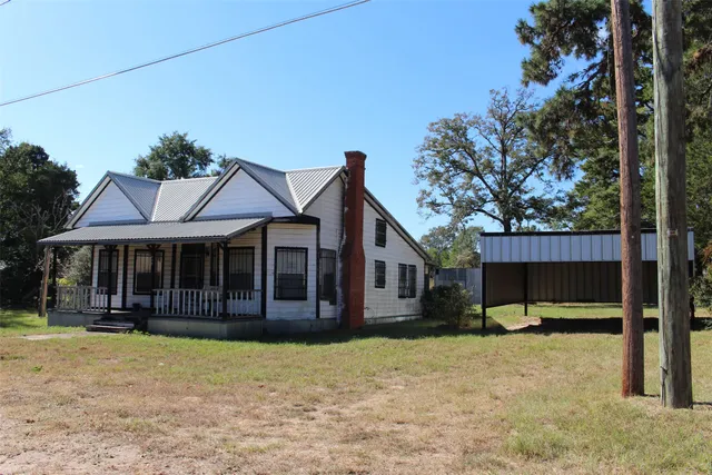 a view of a house with a backyard and porch