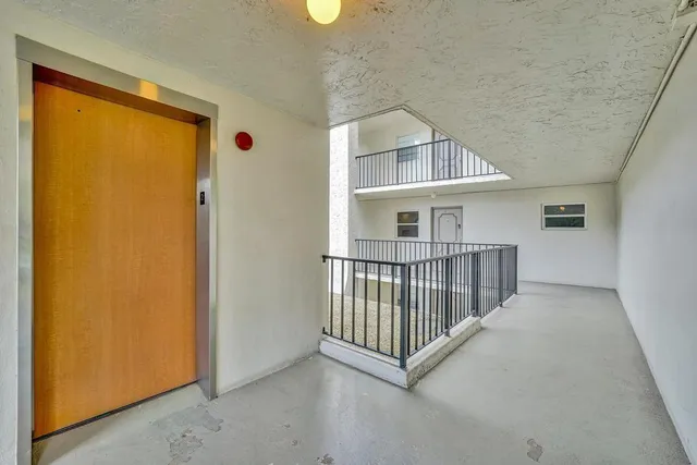 a view of a hallway with wooden floor and entryway