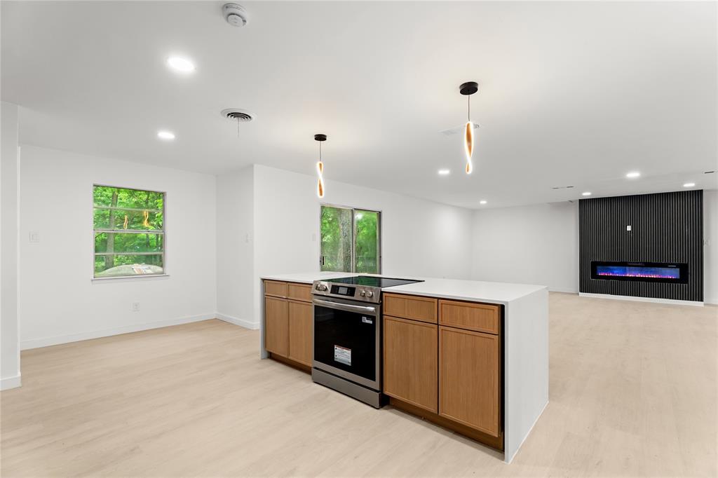110 Hackberry Street Lancaster, TX 75146 - Photo 1 of 32 Modern kitchen island with integrated stainless steel range, light wood-finish cabinetry, and white countertop