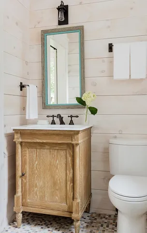 a bathroom with a sink a toilet and mirror