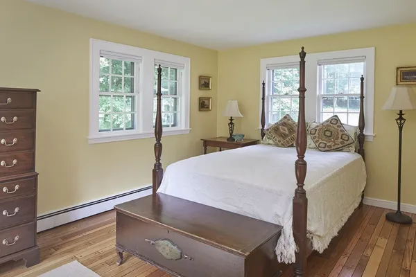 a bedroom with a bed and wooden floor
