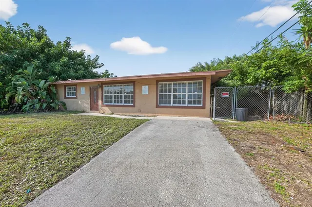 front view of a house with a yard and potted plants