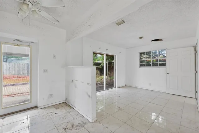 an empty room with a ceiling fan and carpet