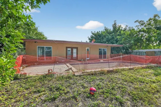 a front view of a house with a yard and potted plants