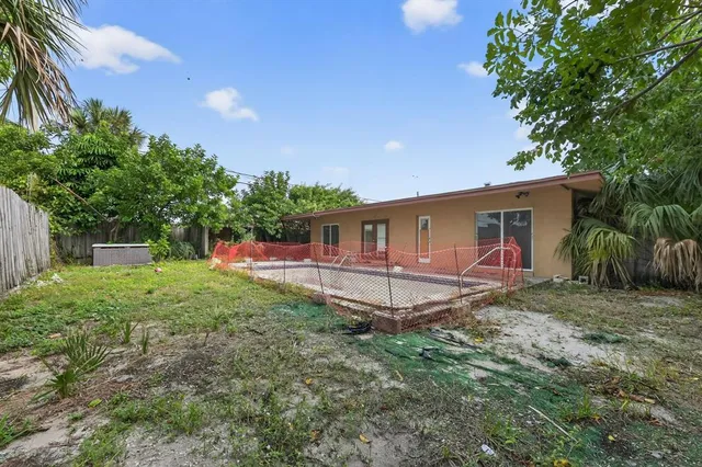a view of a house with backyard and a tree