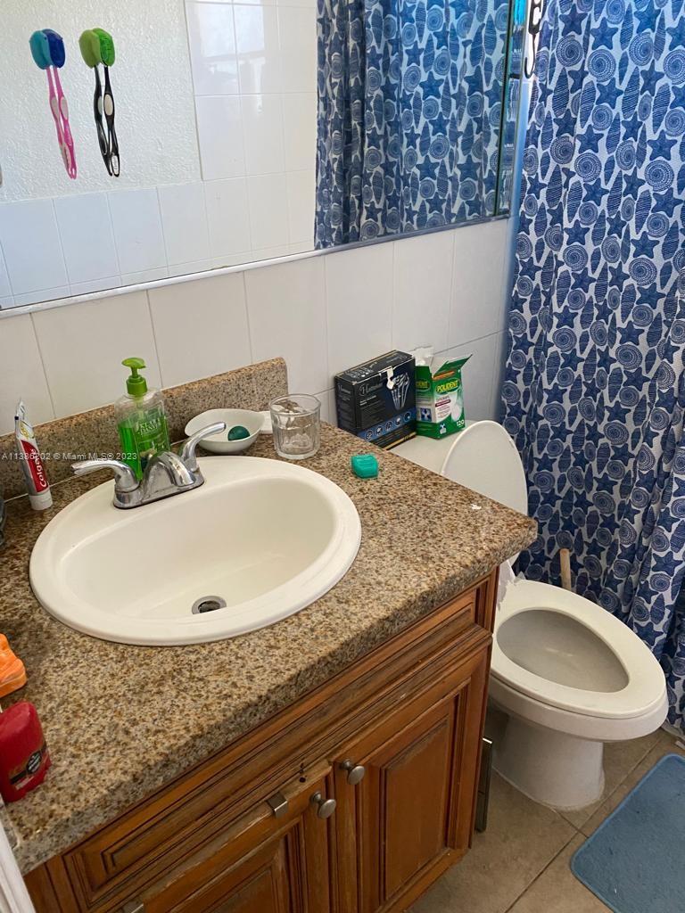 7232 Southwest 94th Place, Unit E7 Miami, FL 33173 - Photo 11 of 11 a bathroom with a granite countertop sink and a mirror