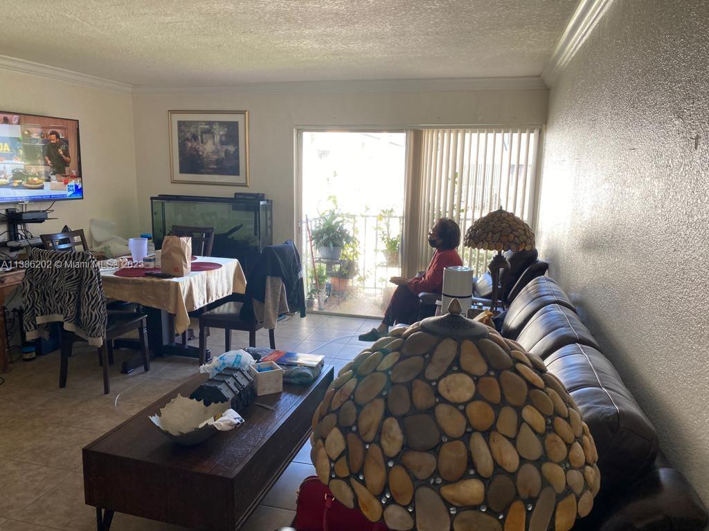 7232 Southwest 94th Place, Unit E7 Miami, FL 33173 - Photo 2 of 11 a living room with furniture and a large window