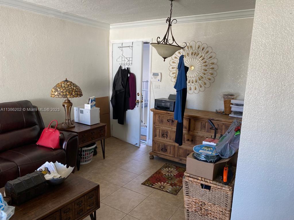 7232 Southwest 94th Place, Unit E7 Miami, FL 33173 - Photo 7 of 11 a living room with furniture and a chandelier
