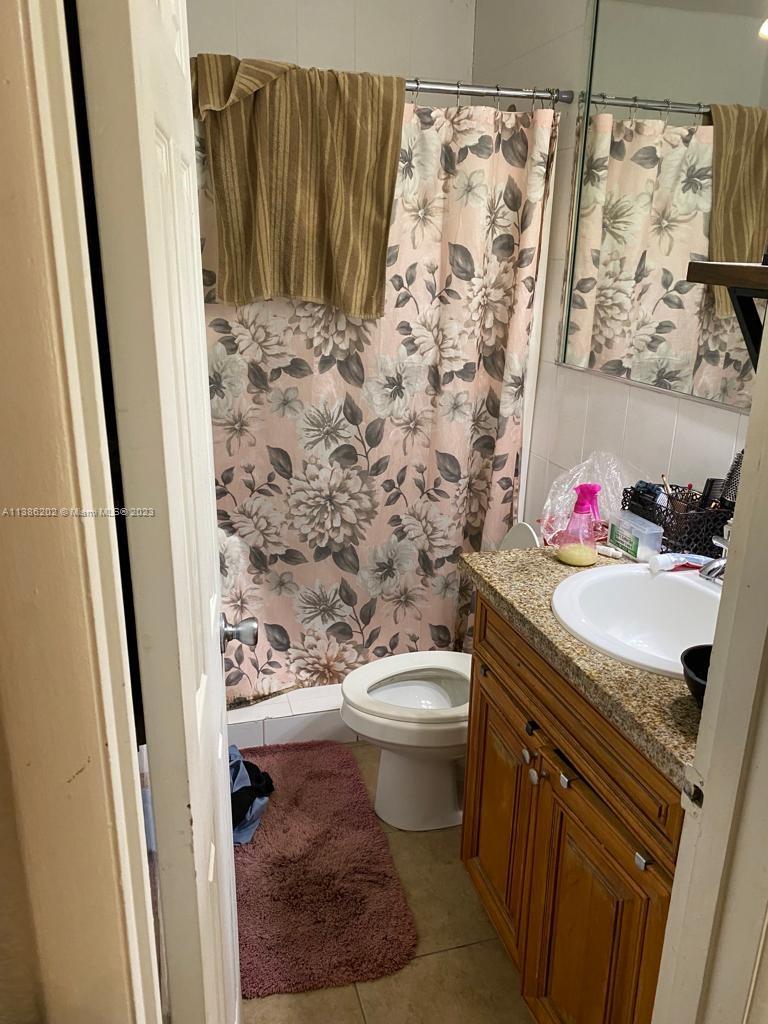 7232 Southwest 94th Place, Unit E7 Miami, FL 33173 - Photo 8 of 11 a bathroom with a granite countertop sink toilet and shower