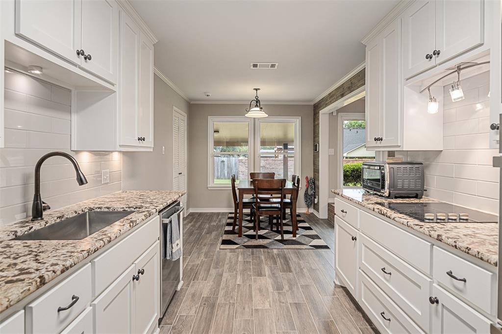 1102 Mill Run Road Athens, TX 75751 - Photo 16 of 35 a kitchen with stainless steel appliances granite countertop a stove a sink dishwasher and white cabinets with wooden floor