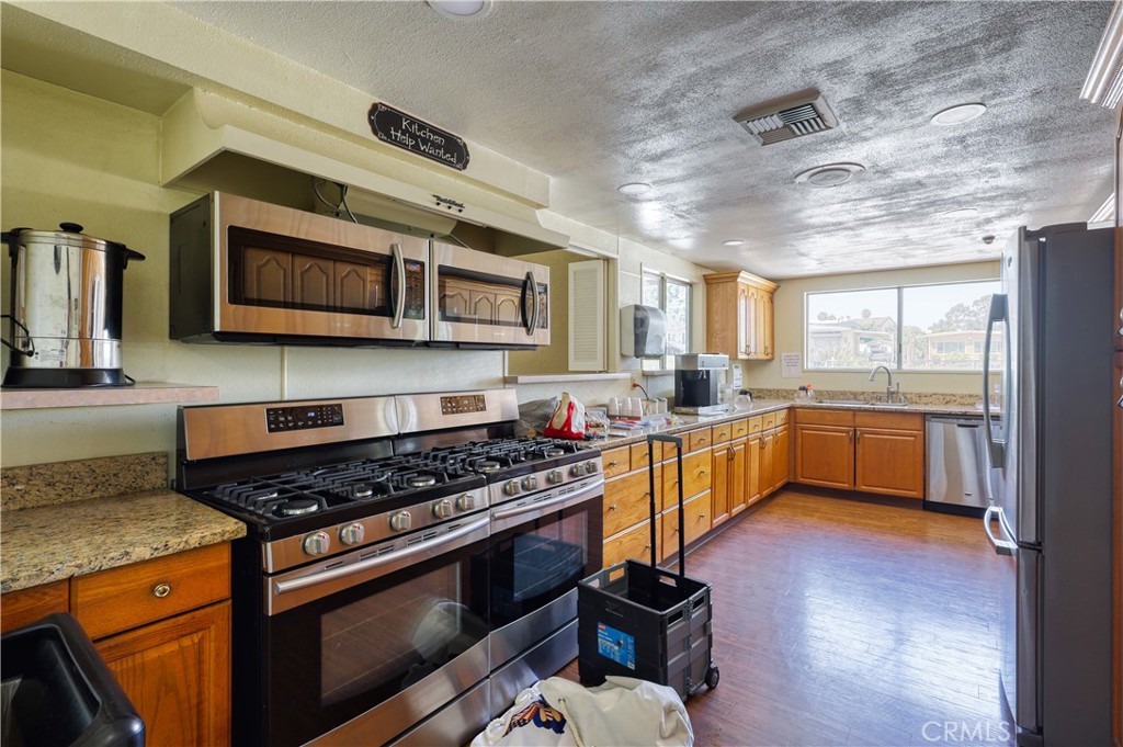 1001 West Lambert Road, Unit 258 La Habra, CA 90631 - Photo 74 of 75 a kitchen with stainless steel appliances kitchen island granite countertop a stove a sink and a microwave
