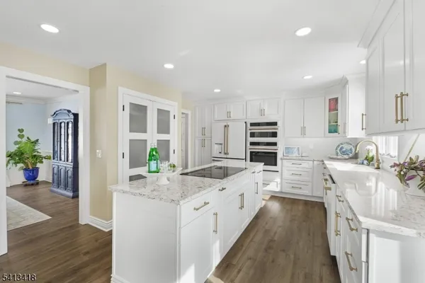 a kitchen with stainless steel appliances kitchen island granite countertop a stove and cabinets
