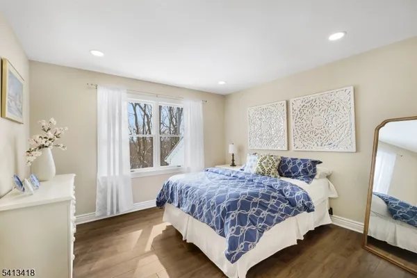 a bedroom with a bed wooden floor and window
