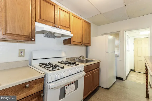 a kitchen with stainless steel appliances granite countertop a stove a refrigerator and a cabinets