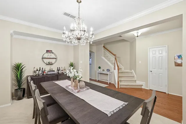 a view of a dining room with furniture a chandelier and wooden floor