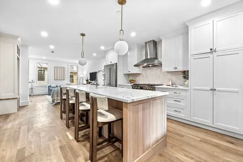 a kitchen with stainless steel appliances kitchen island granite countertop a stove a sink and a refrigerator