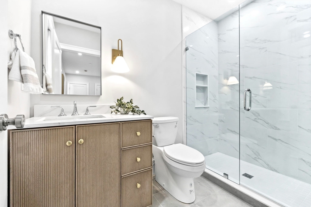 12 Prospect Street, Unit 1 Boston, MA 02129 - Photo 10 of 20 a bathroom with a shower sink vanity mirror and toilet