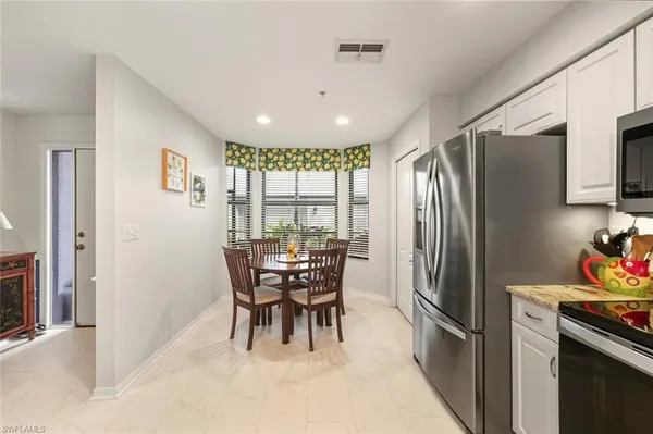 a kitchen with stainless steel appliances granite countertop a refrigerator and a stove top oven