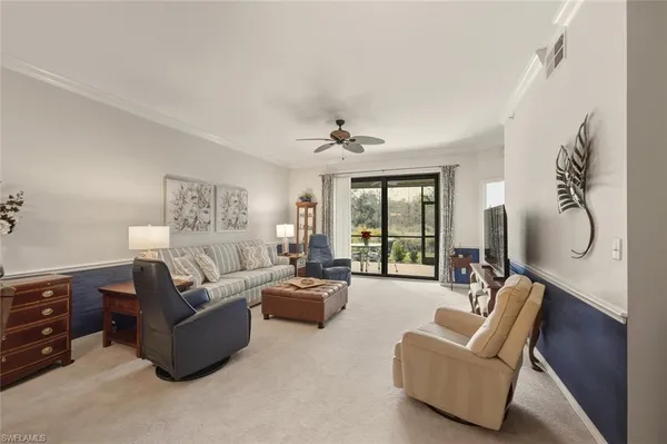 a living room with furniture ceiling fan and a window