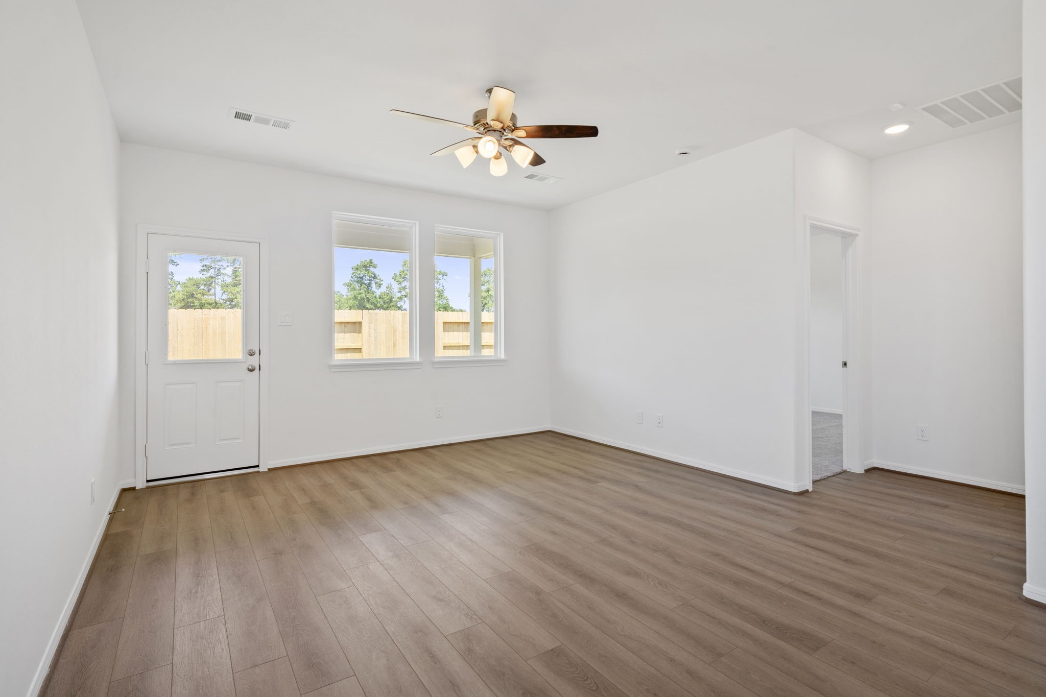 23619 Cinnamon Tree Lane Katy, TX 77493 - Photo 11 of 33 an empty room with wooden floor chandelier and windows