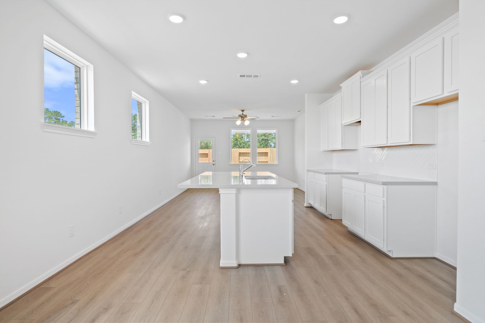 23619 Cinnamon Tree Lane Katy, TX 77493 - Photo 8 of 33 a kitchen with wooden floors and white walls