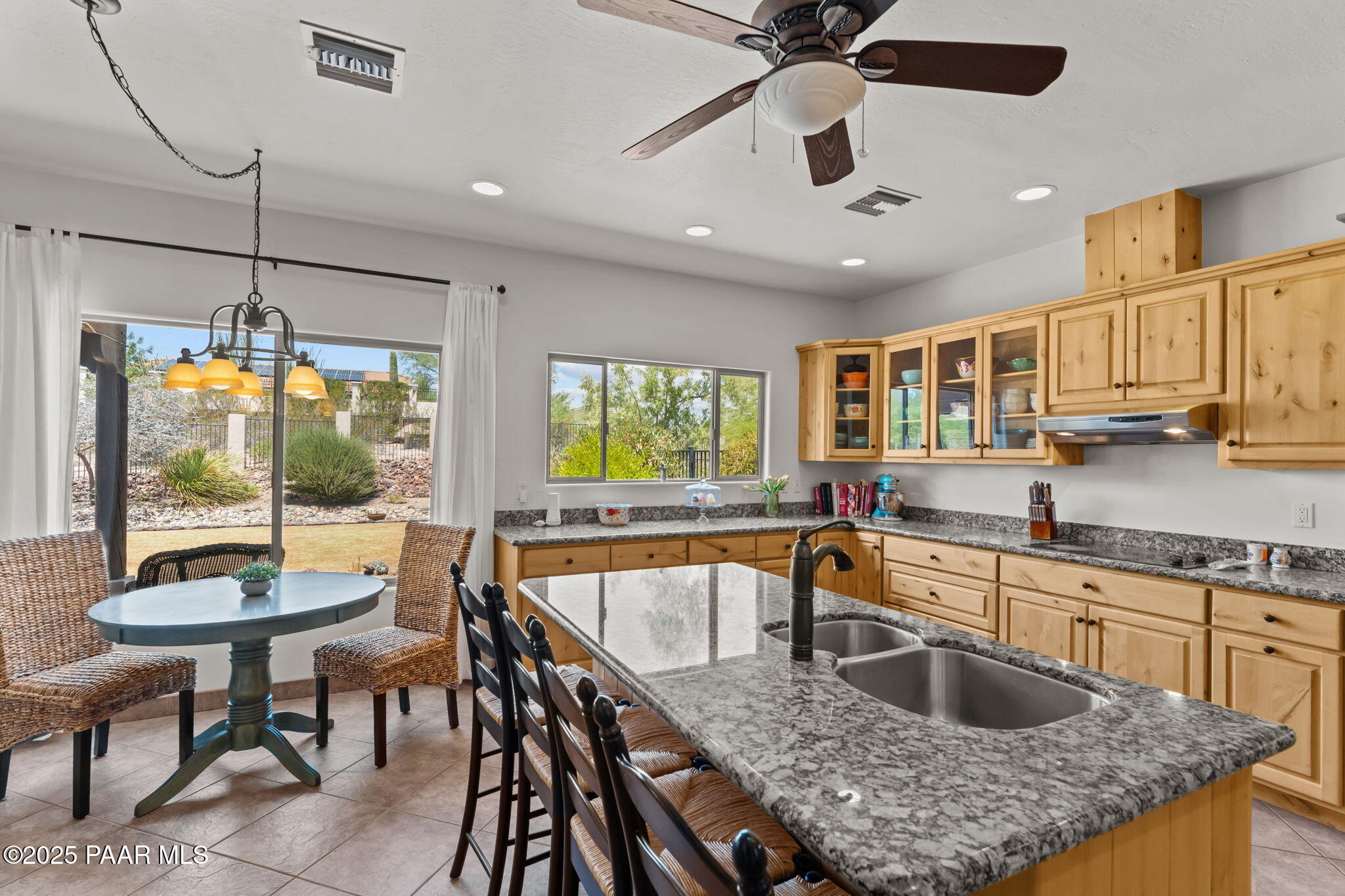 2100 West Silverlode Drive Wickenburg, AZ 85390 - Photo 18 of 51 a kitchen with a stove a sink a table and chairs