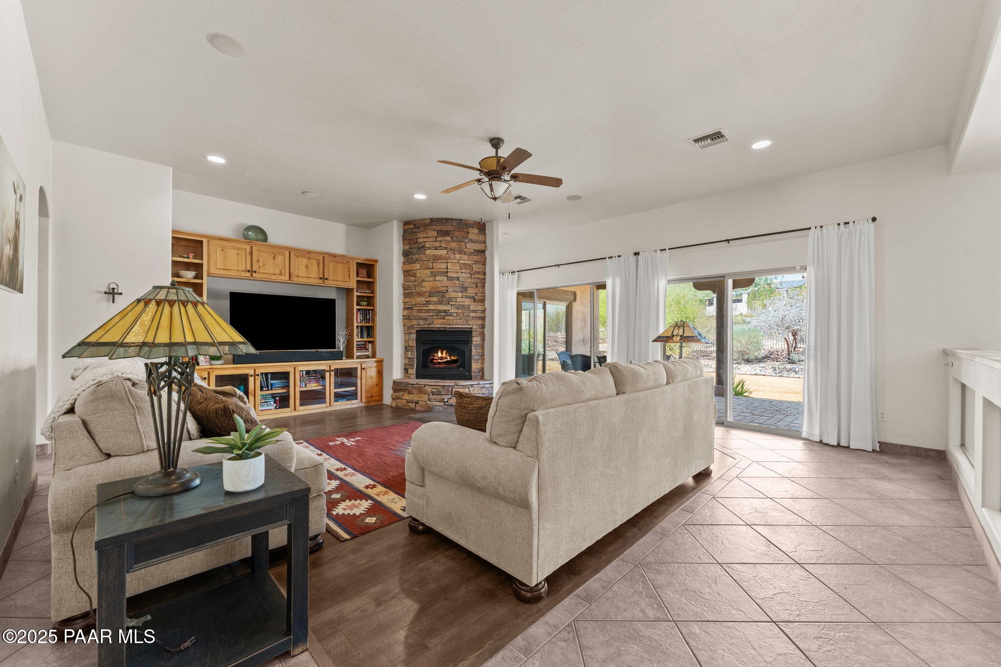 2100 West Silverlode Drive Wickenburg, AZ 85390 - Photo 8 of 51 a living room with furniture a flat screen tv and a fireplace
