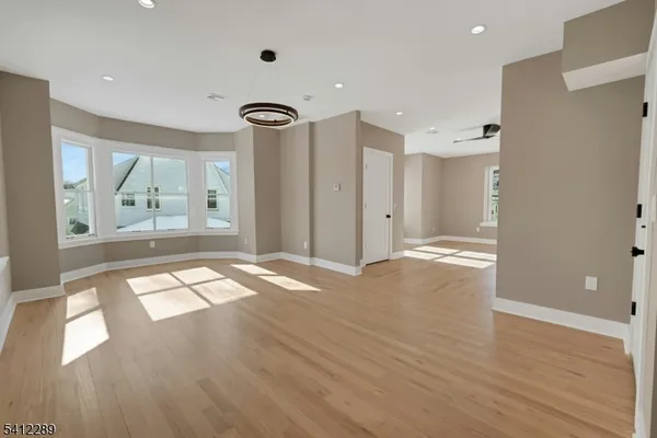 a view of empty room with wooden floor and window