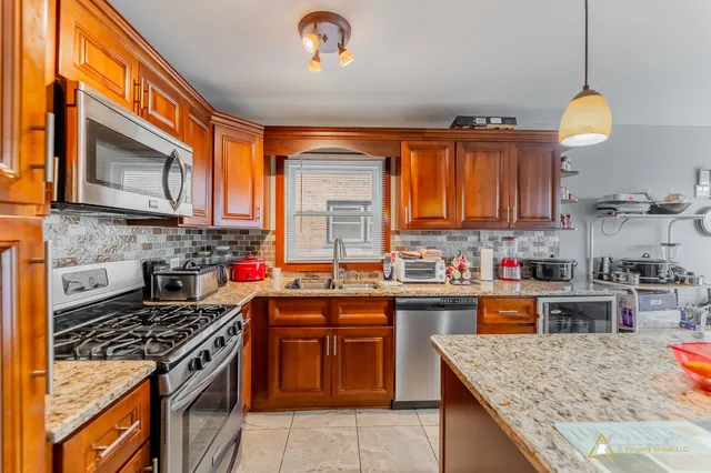 a kitchen with stainless steel appliances granite countertop a stove top oven a sink dishwasher and a microwave oven on the granite countertops