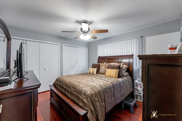 a bedroom with a bed and a flat tv screen on dresser