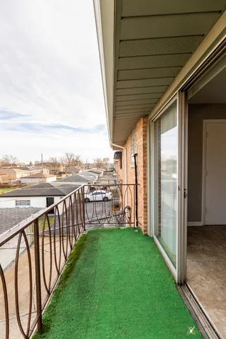 a view of a deck with a big yard potted plants and floor to ceiling window