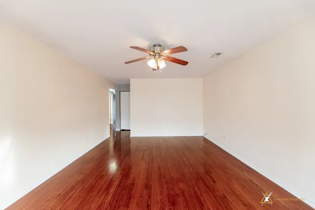 a view of empty room with wooden floor