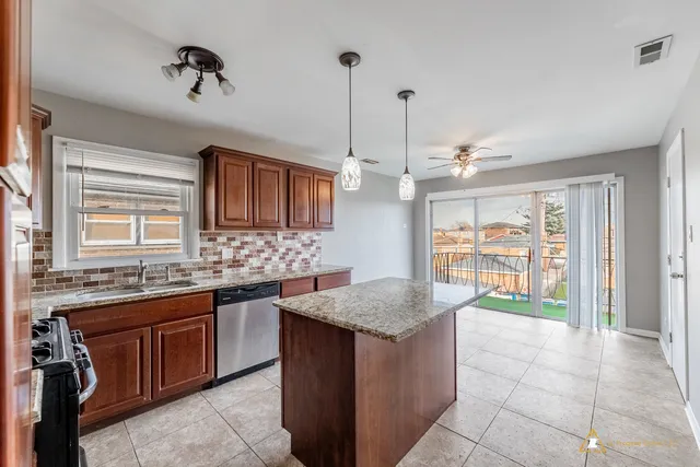 a kitchen with kitchen island granite countertop a sink stove and a granite counter top