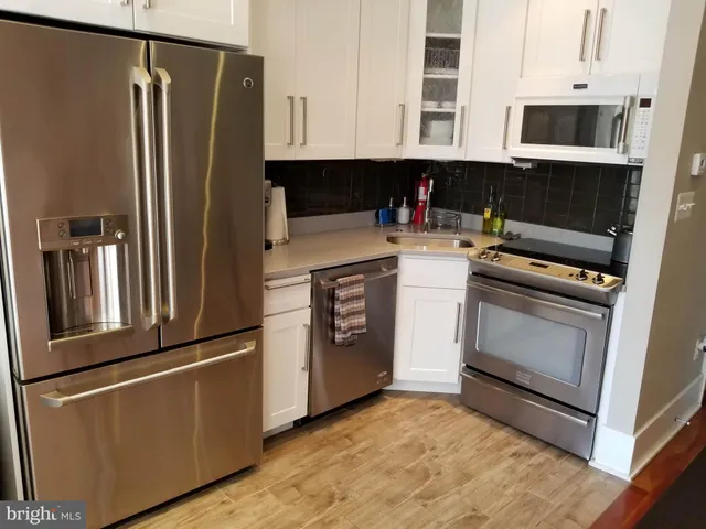 a kitchen with stainless steel appliances granite countertop a refrigerator a stove and a microwave